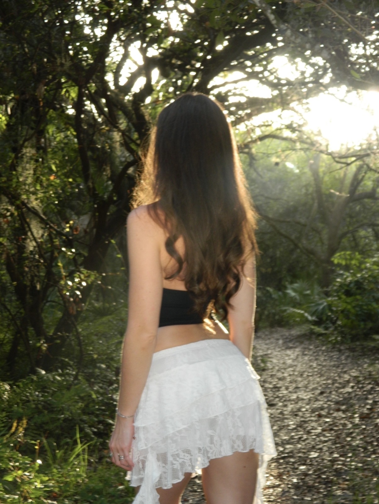Julia Melo walking away into soft forest light