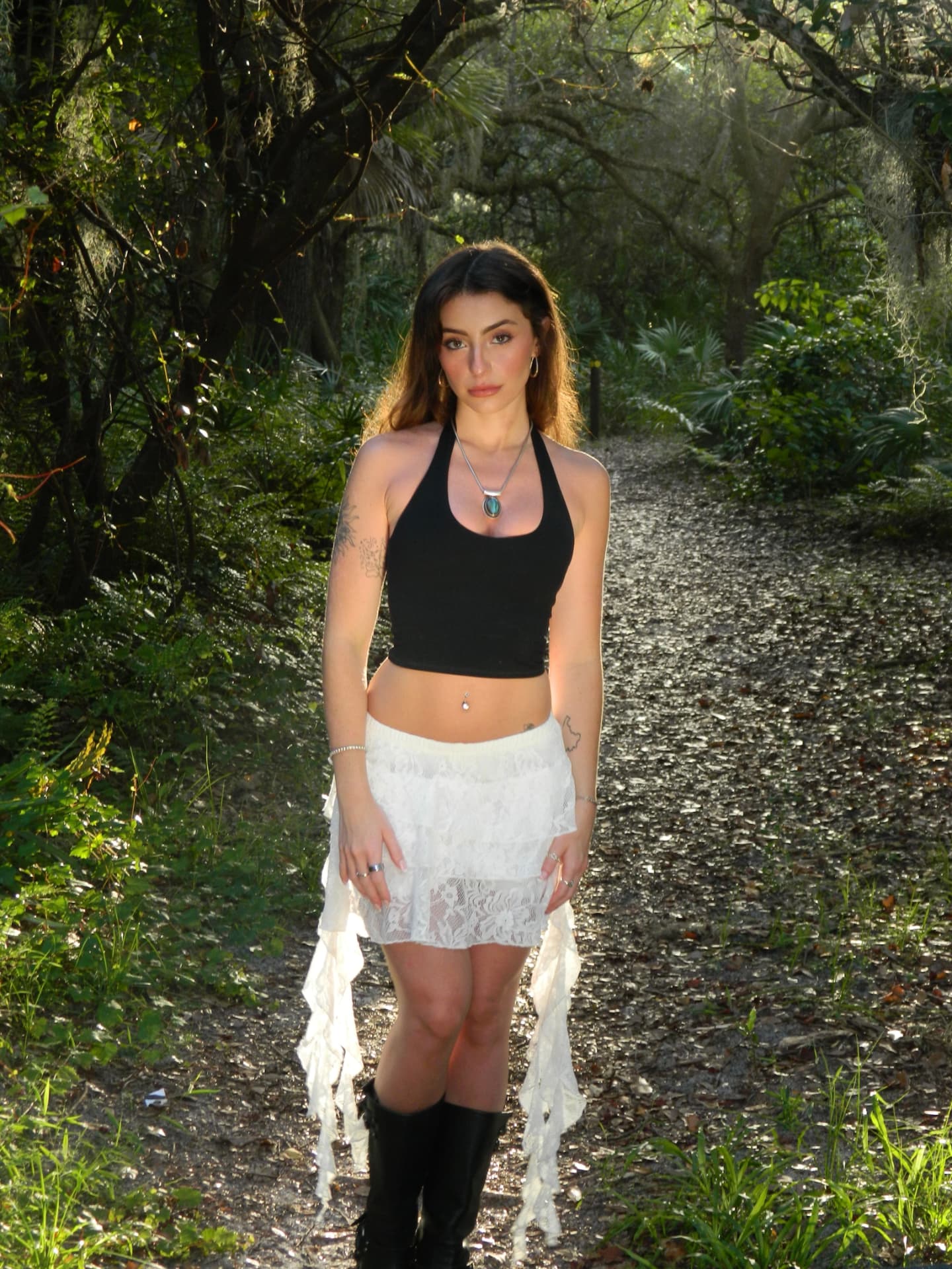 Full-length portrait standing on a shaded woodland path